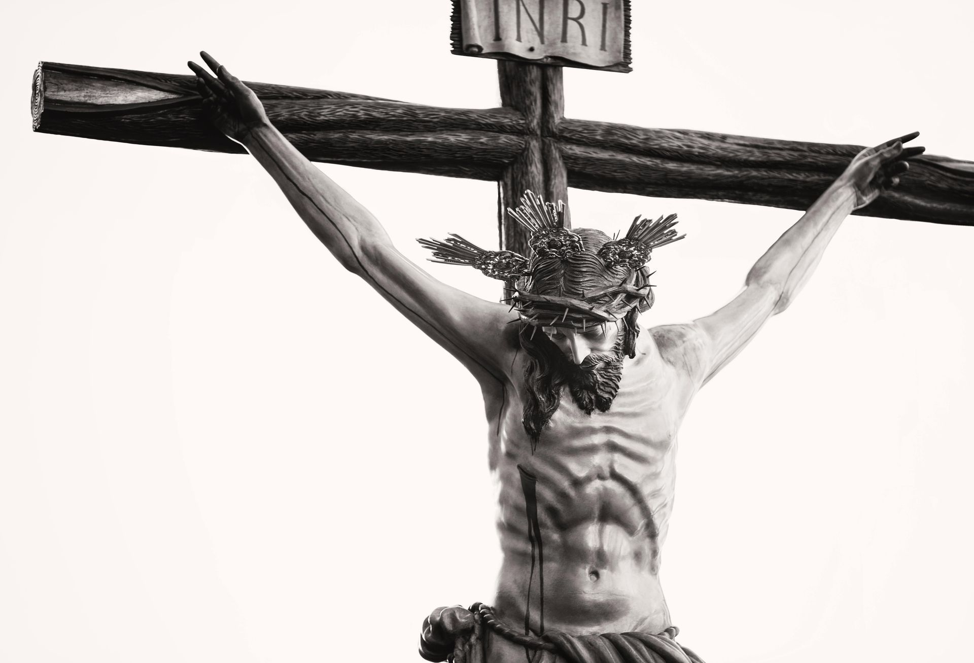 Crucifix of Jesus Christ, black and white. Christ on a wooden cross, arms outstretched, crown of thorns.