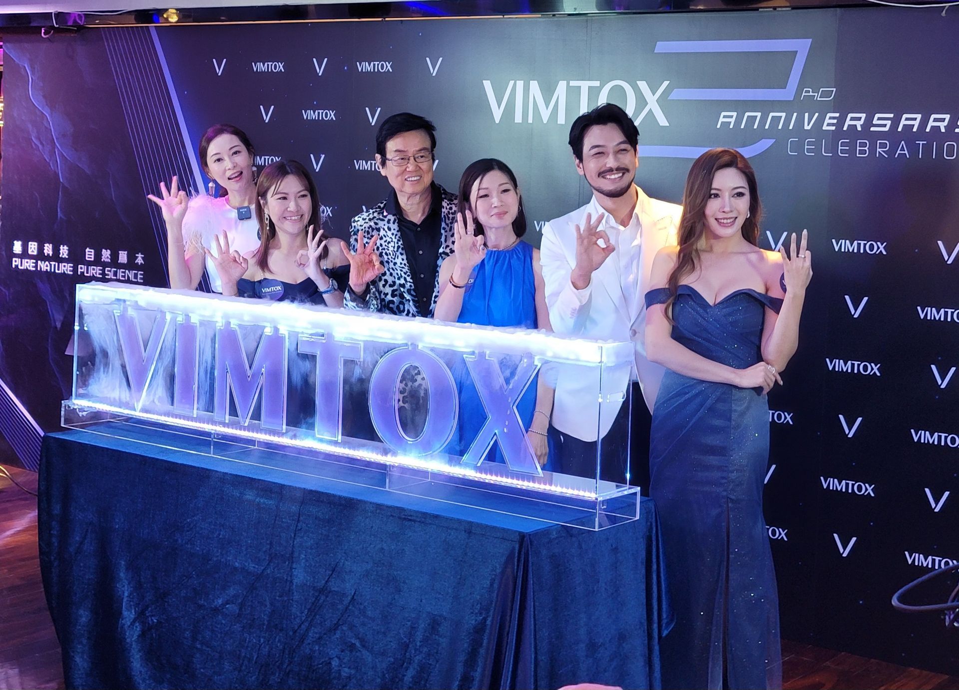 一群人站在寫著 vimtox 的牌子前