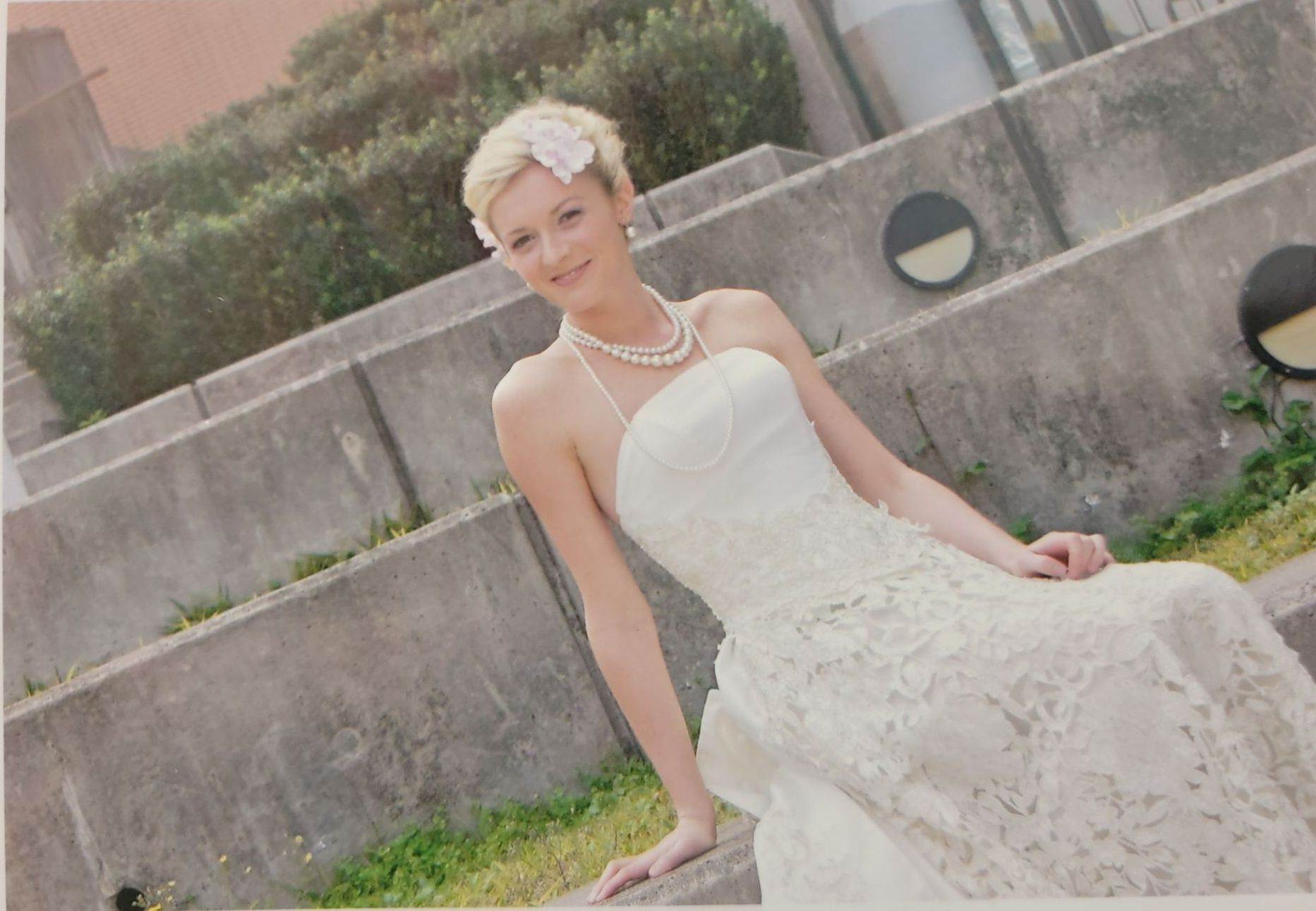 一個穿著婚紗的女人坐在牆上