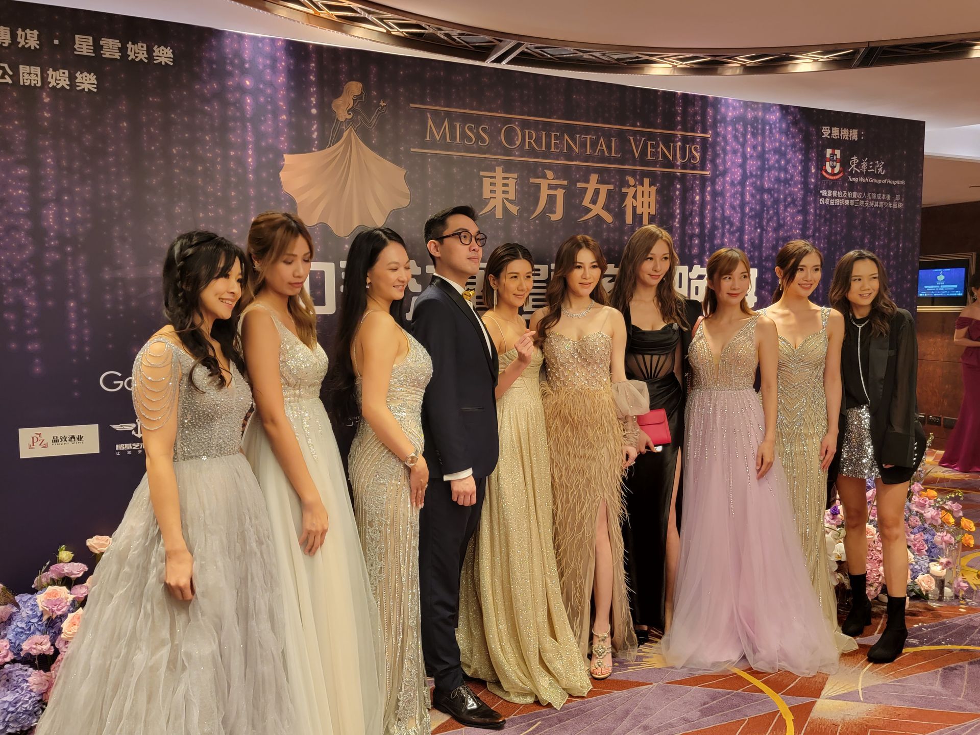 A group of women in dresses are posing for a picture.