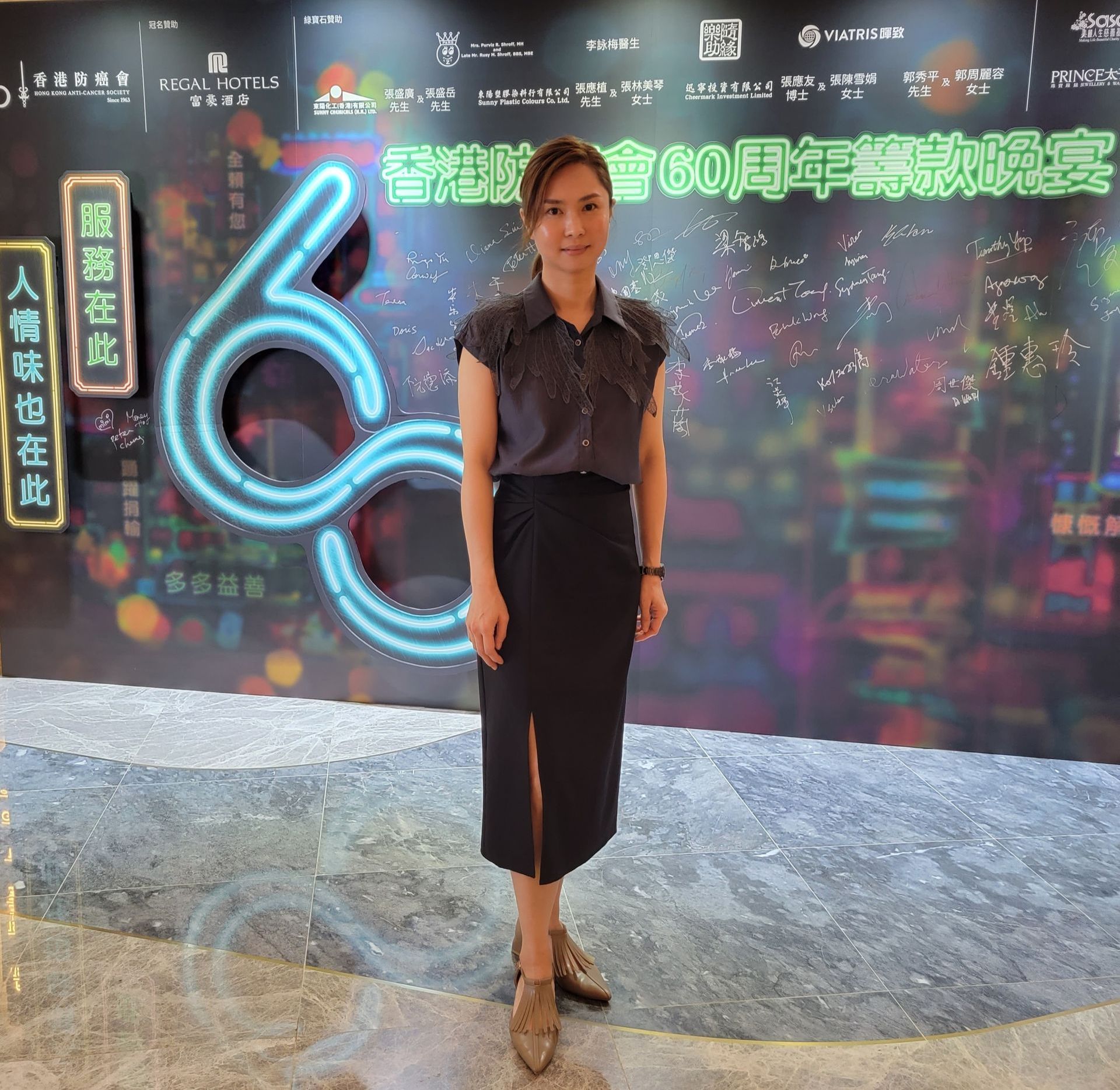 A woman stands in front of a sign that says 60