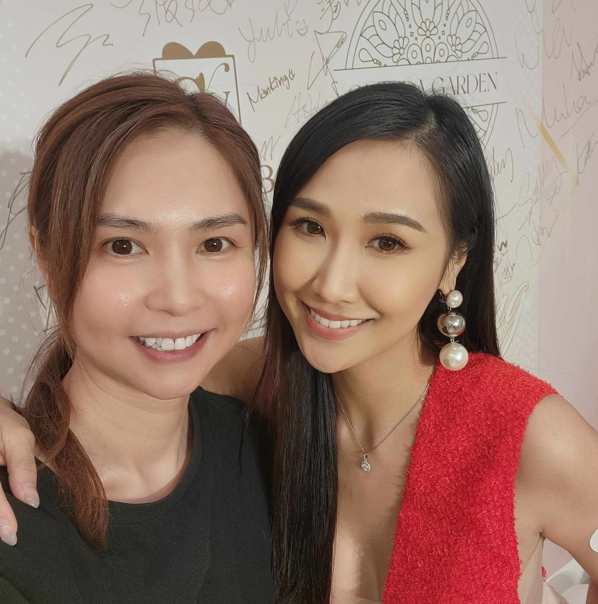 兩名女子正在擺姿勢拍照，其中一名穿著紅色連身裙