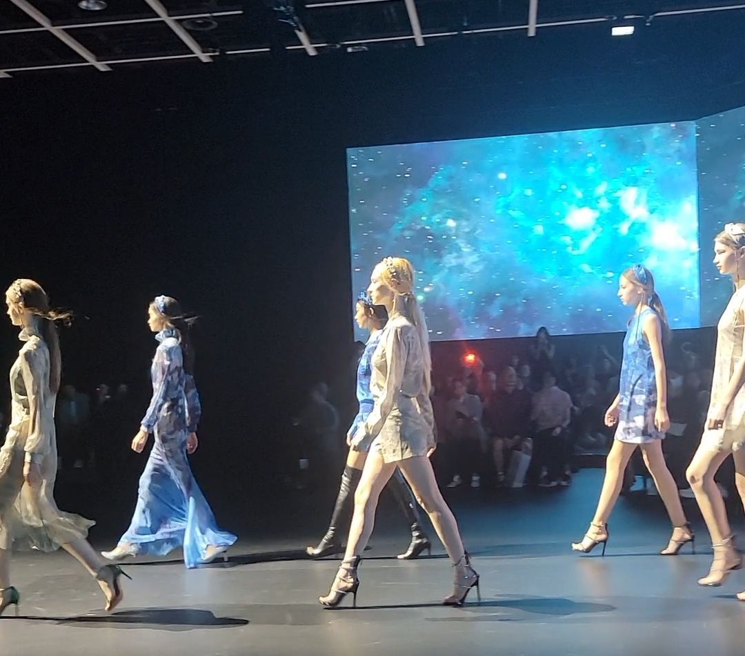 A group of women are walking down a runway at a fashion show
