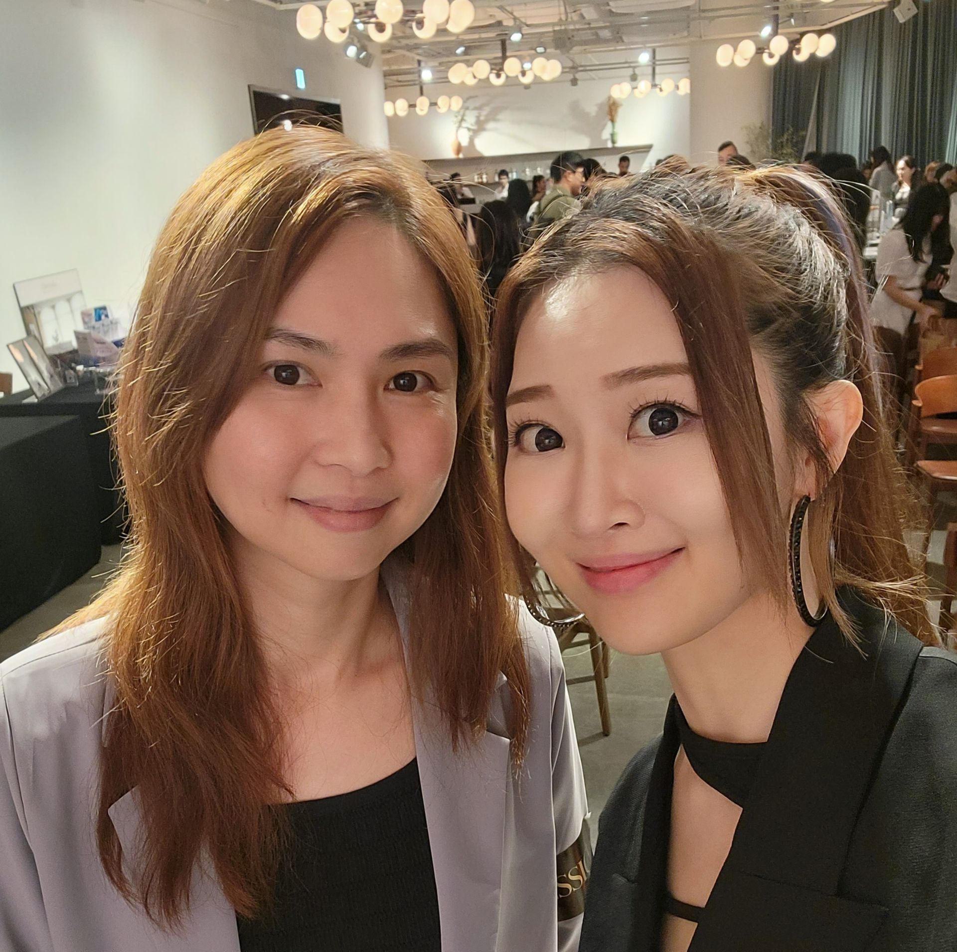 兩個女人在房間裡一起擺姿勢拍照