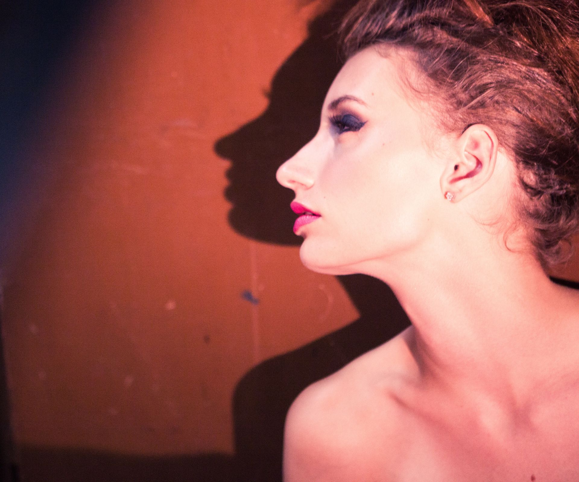 一個女人,她身後的牆上有個影子