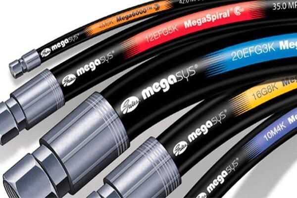 Mangueras hidráulicas negras con racores plateados y etiquetas de colores, dispuestas en diagonal sobre un fondo blanco.