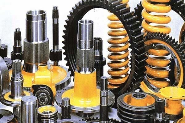 Surtido de piezas de suspensión y muelles helicoidales de color amarillo y negro para automóviles, expuestas en un taller.