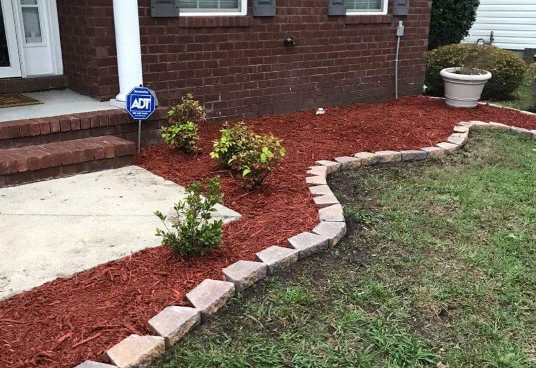 A brick house with a brick walkway leading to the front door.