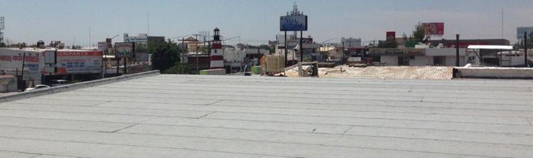 Vista panorámica de la ciudad desde una azotea en un día soleado. Al fondo se aprecian edificios y cielo.