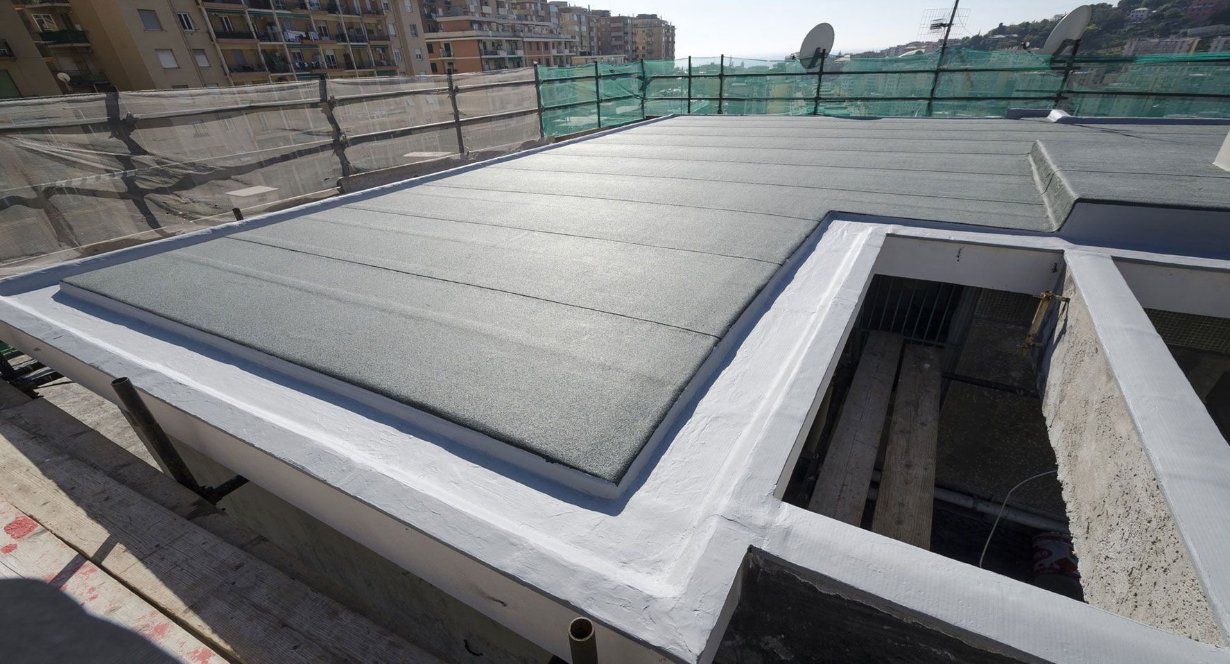 Techo plano de color gris oscuro con molduras blancas y un pozo empotrado, probablemente en construcción.