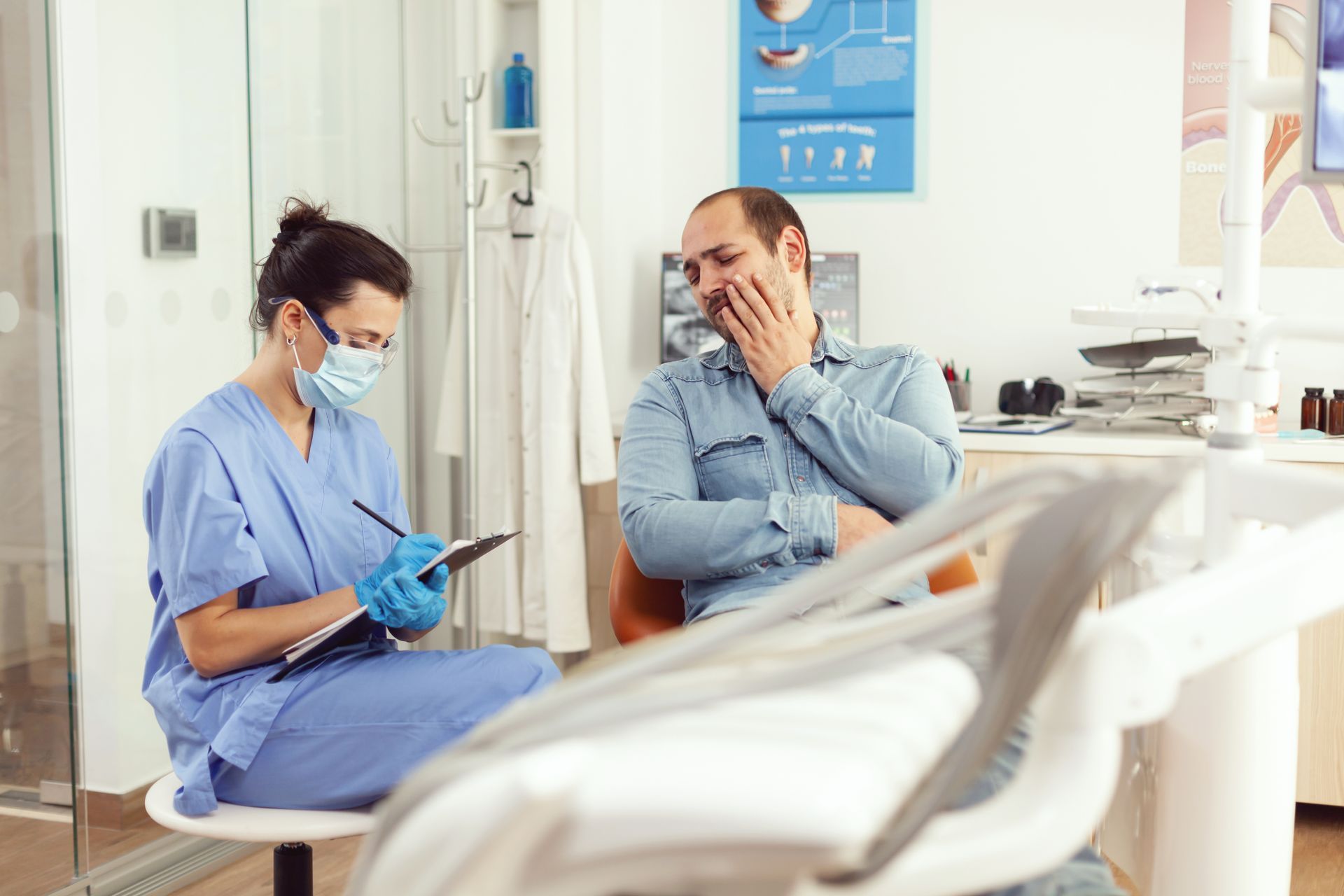 A dentist is talking to a patient in a dental office.