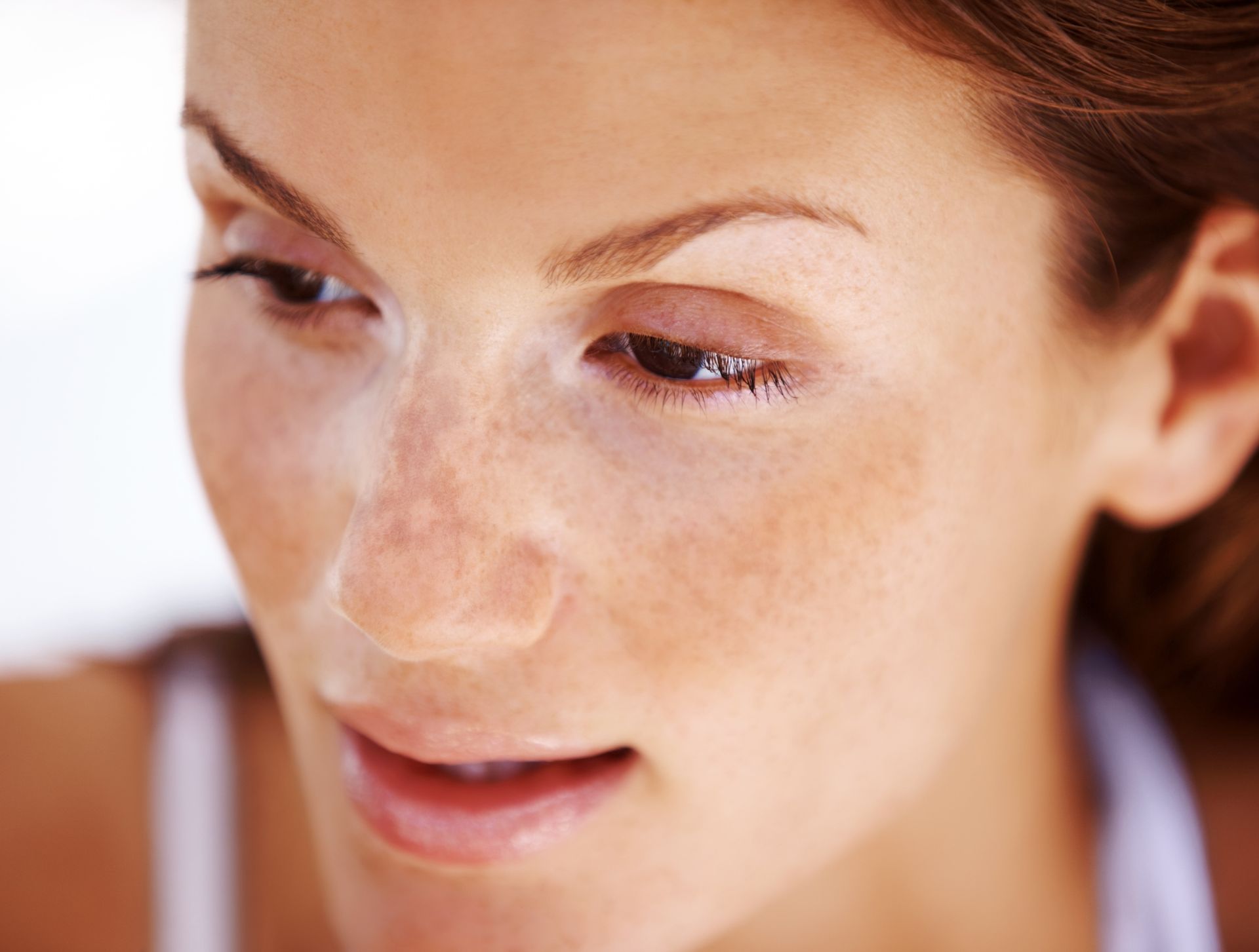 A close up of a woman 's face with freckles.