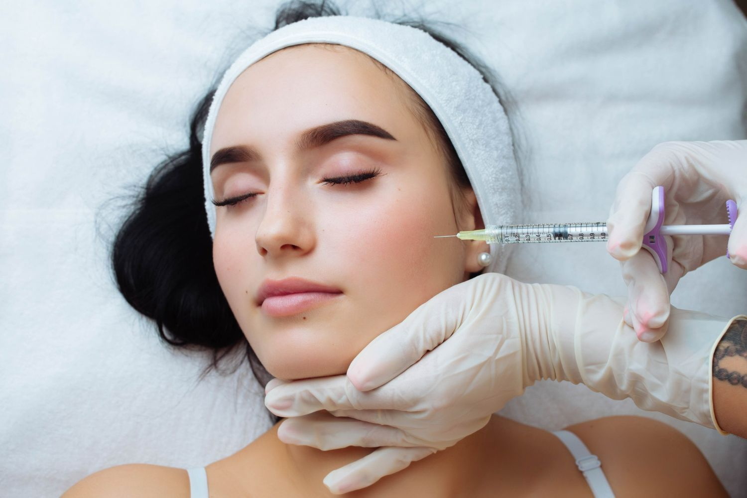 Cosmetic injection being administered to a relaxed client lying on a treatment bed