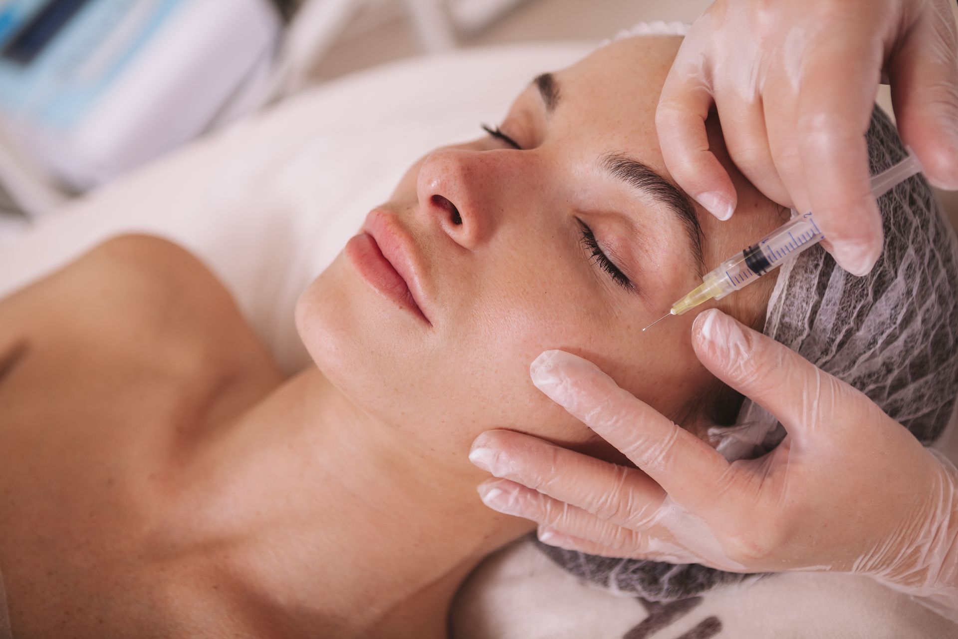 A woman is getting a botox injection in her face.