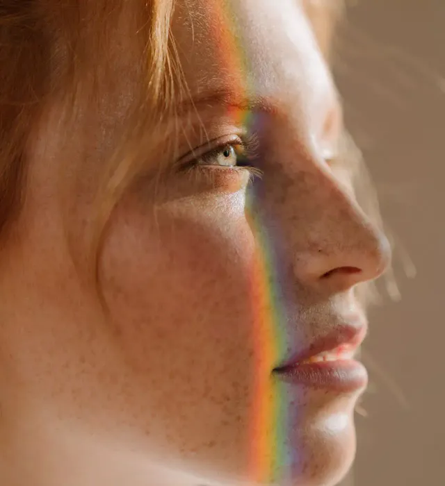 A woman is pointing at her nose with her finger.