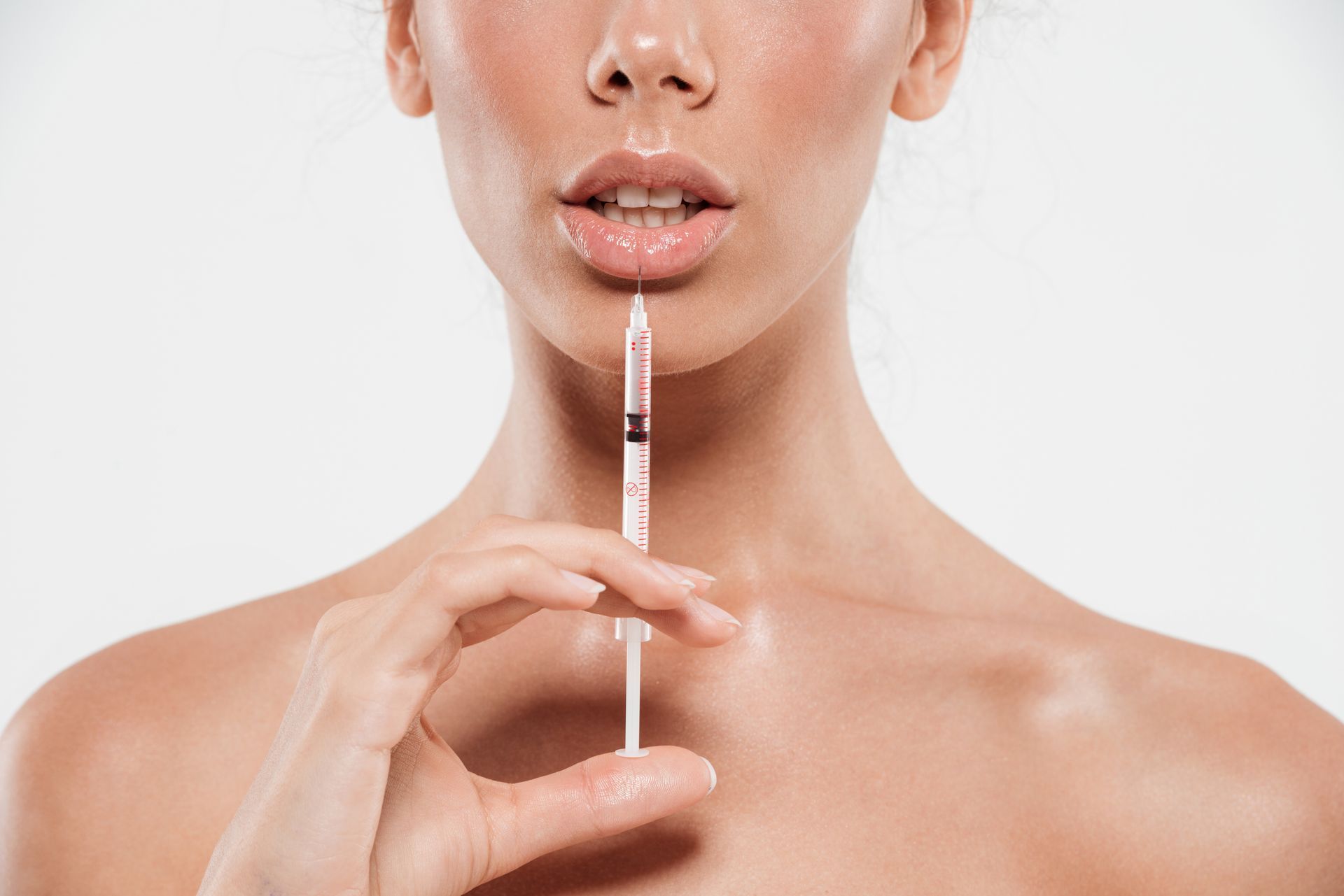 A woman is holding a syringe in her mouth.