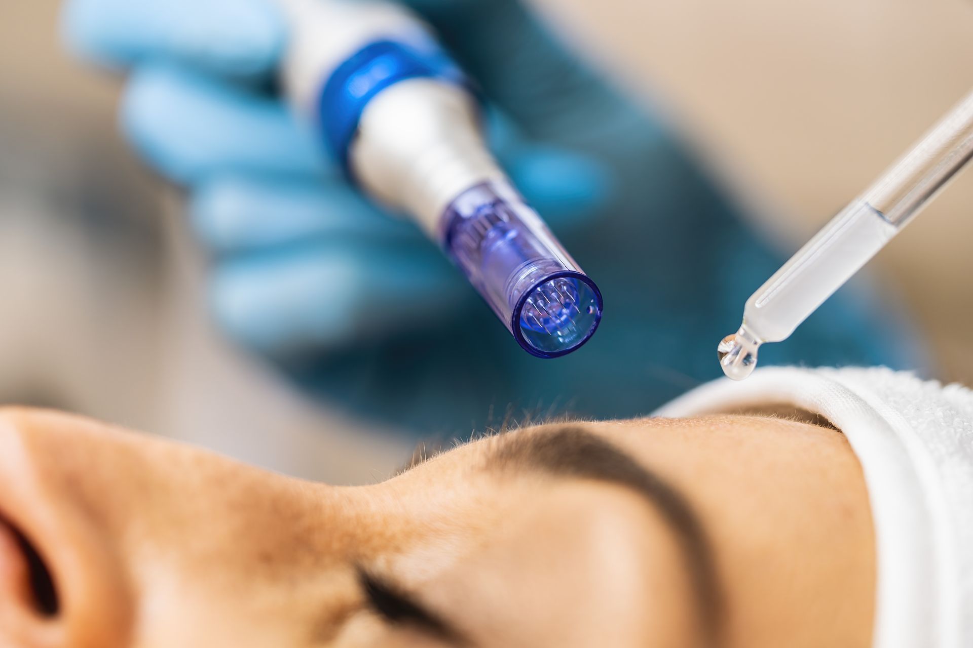 A woman is getting a facial treatment with a dropper.