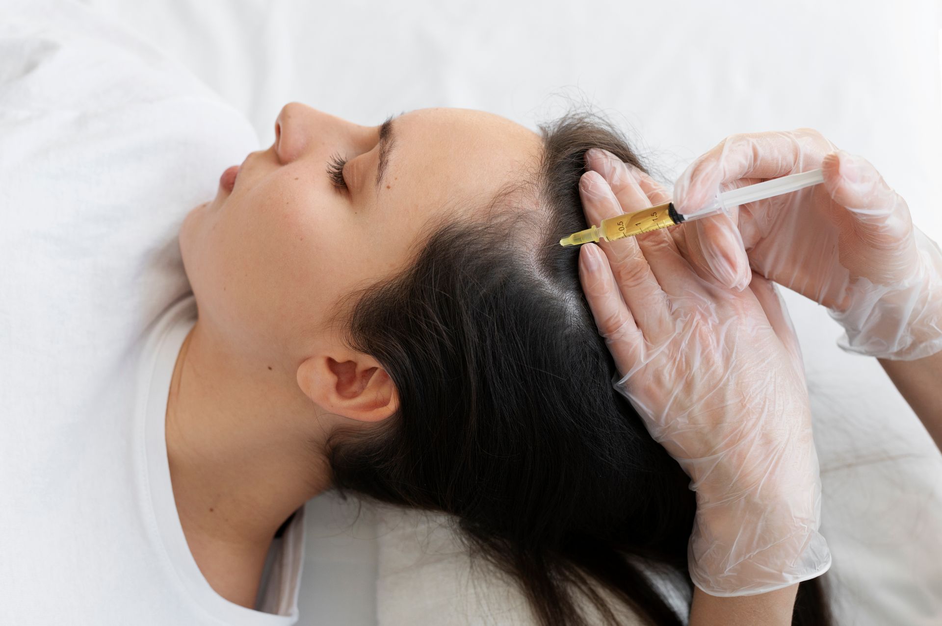 A woman is getting an injection in her hair.