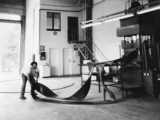 foto in bianco e nero di un uomo in una fabbrica con in mano  della gomma per guarnizioni