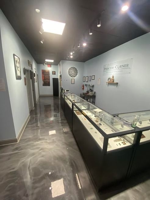 Jewelry store interior with display cases, gray epoxy floor, and light blue walls.