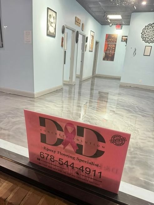 Shiny epoxy floor in a hallway with light blue walls and a pink sign for 