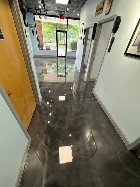 Hallway with metallic gray epoxy floor, light blue walls, and yellow door.