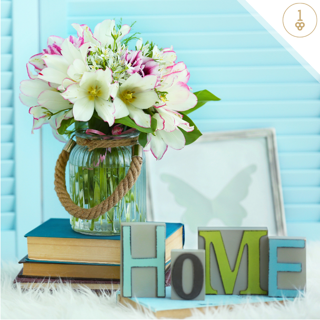 a vase of flowers sits next to a sign that says home