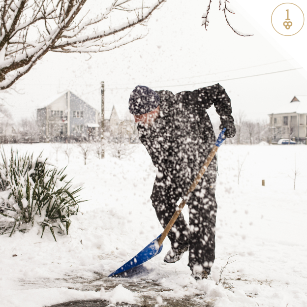 a man is shoveling snow with a blue shovel