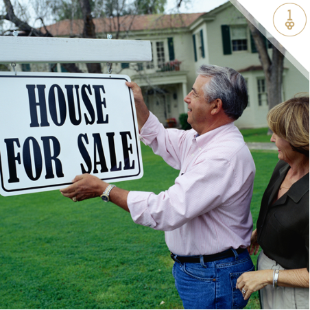 Older couple putting up a house for sale sign