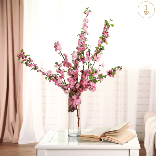 a vase filled with pink flowers sits on a table next to an open book