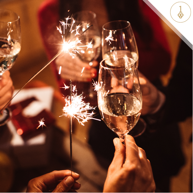 a group of people holding sparklers and wine glasses