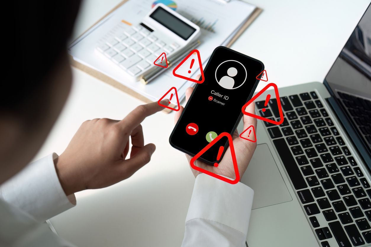 Person holding a smartphone with incoming call, surrounded by red warning symbols.