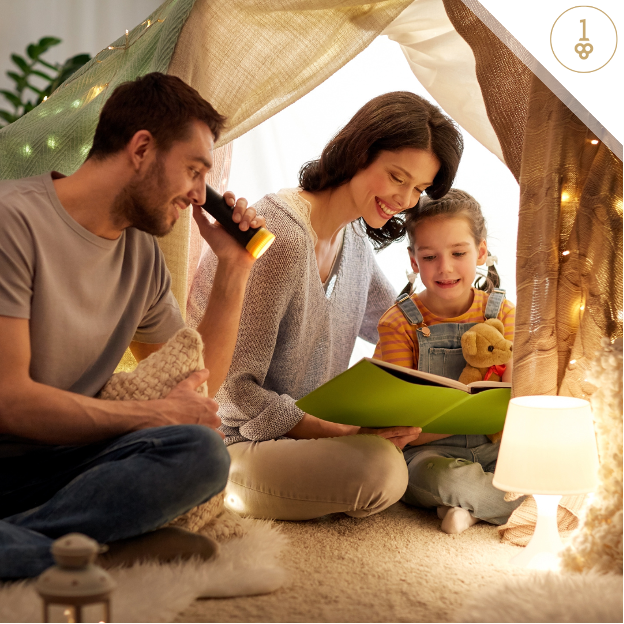 a family sits under a tent reading a book