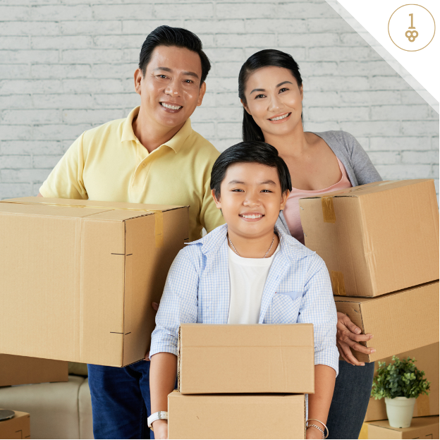 Young family smiling carrying moving boxes