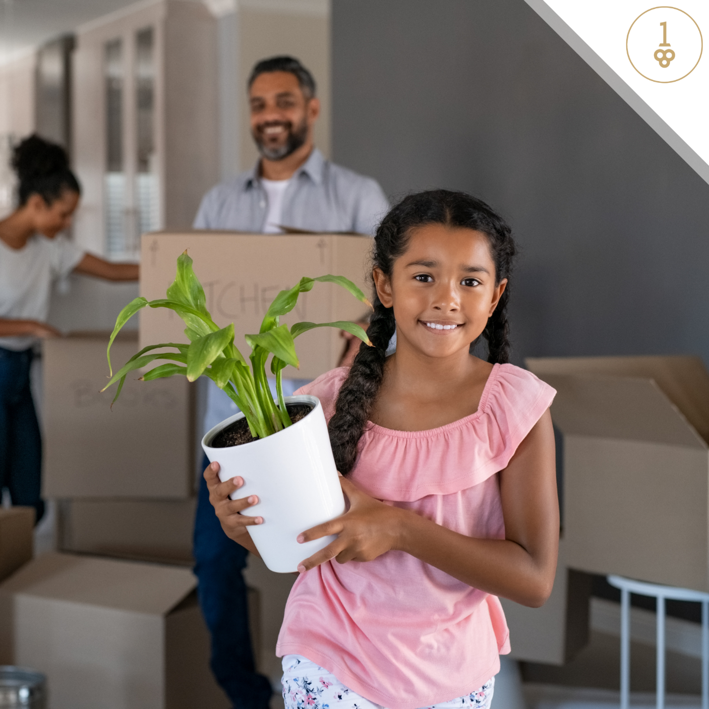 A little girl is holding a potted plant in a new home.