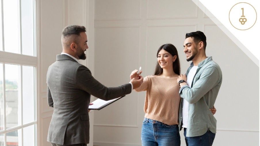 Young couple with agent handing them a key