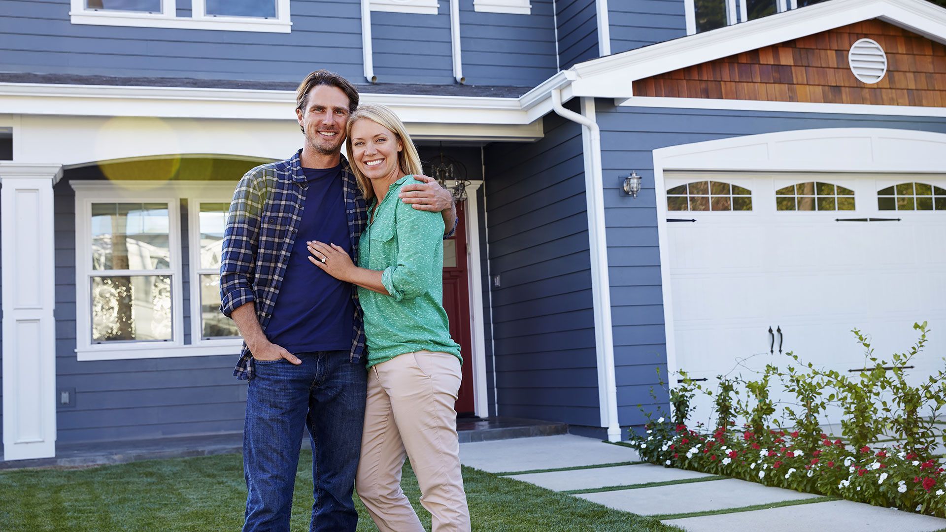 Portrait of couple standing outside house