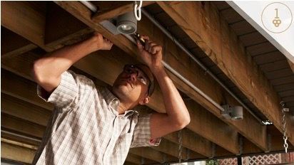 Man with safety glasses and screwdriver adjusting ceiling lights