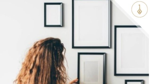 Woman hanging frames on wall