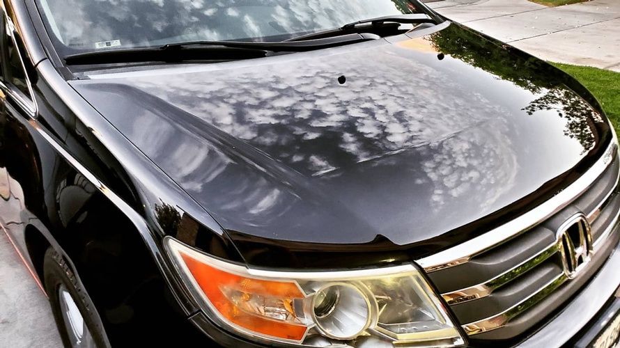 A black honda ridgeline is parked on the side of the road.