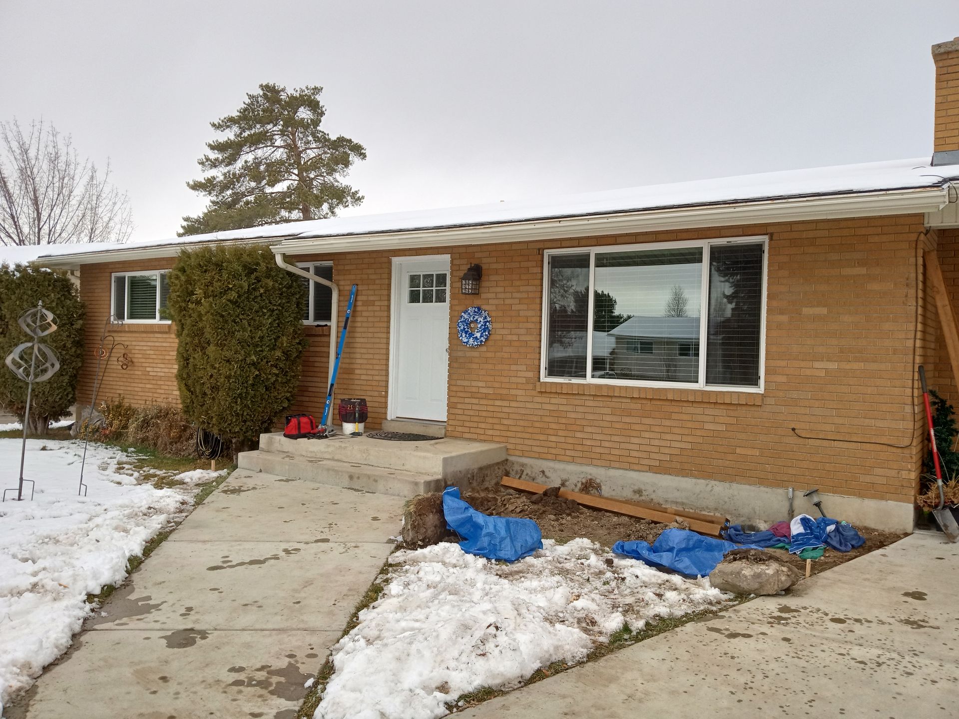 A brick house with snow on the ground in front of it
