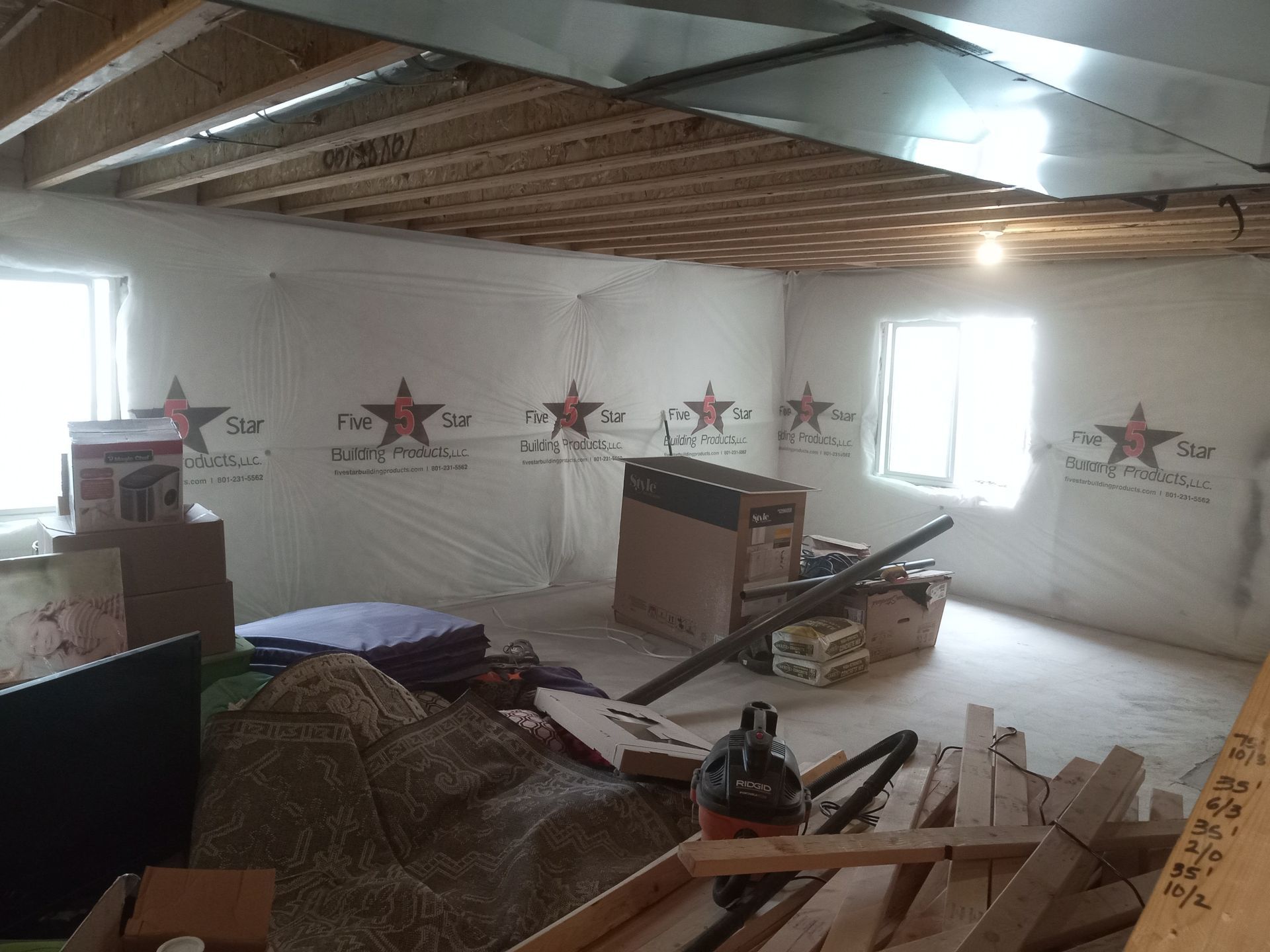 A room with a lot of boxes and a vacuum cleaner in it.