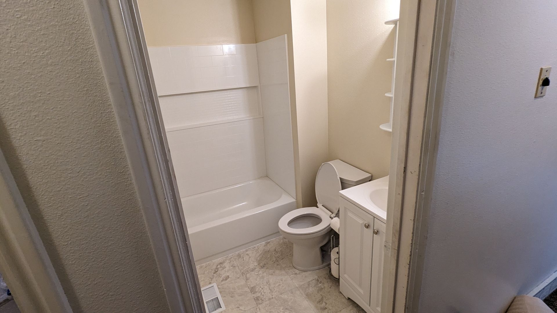 A bathroom with a toilet , sink and bathtub.