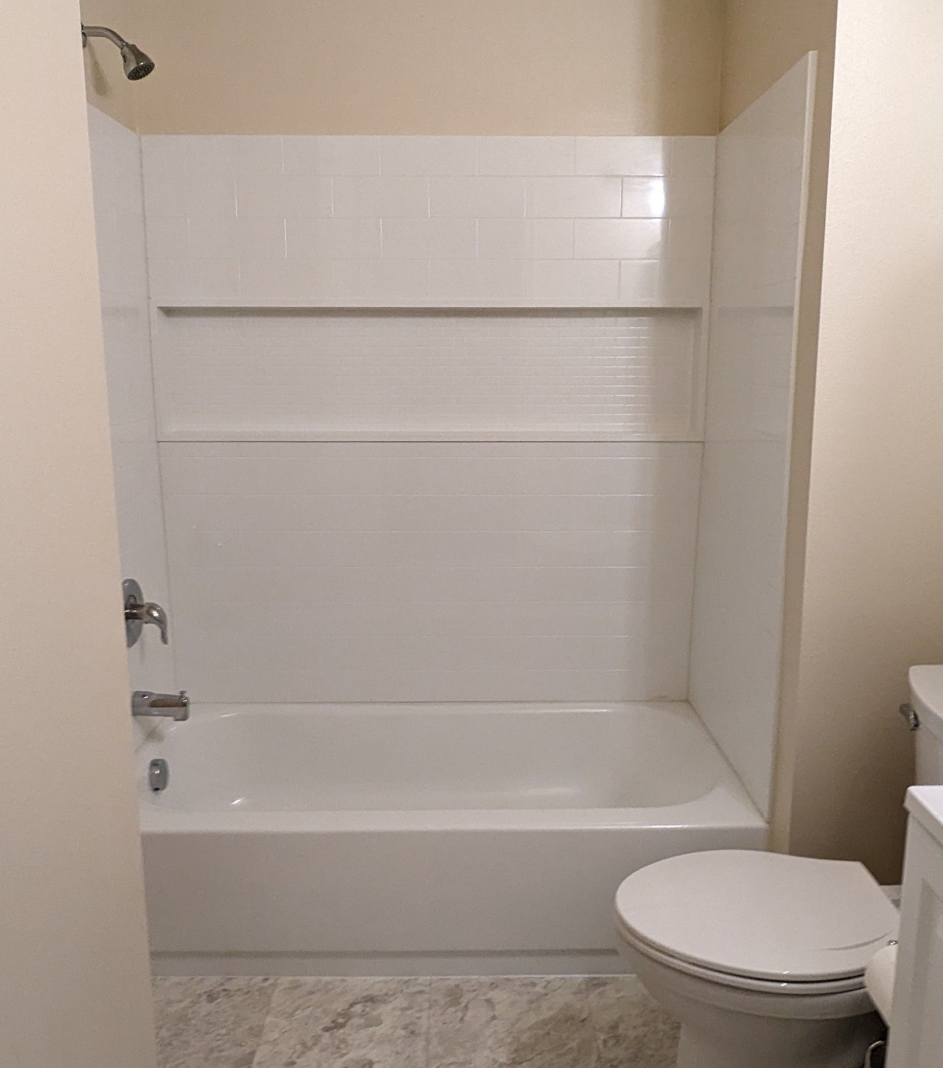 A bathroom with a tub , toilet and shower.