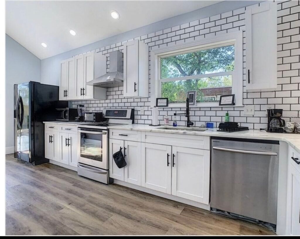 A kitchen with white cabinets and stainless steel appliances
