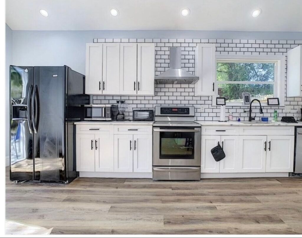 A kitchen with white cabinets and stainless steel appliances