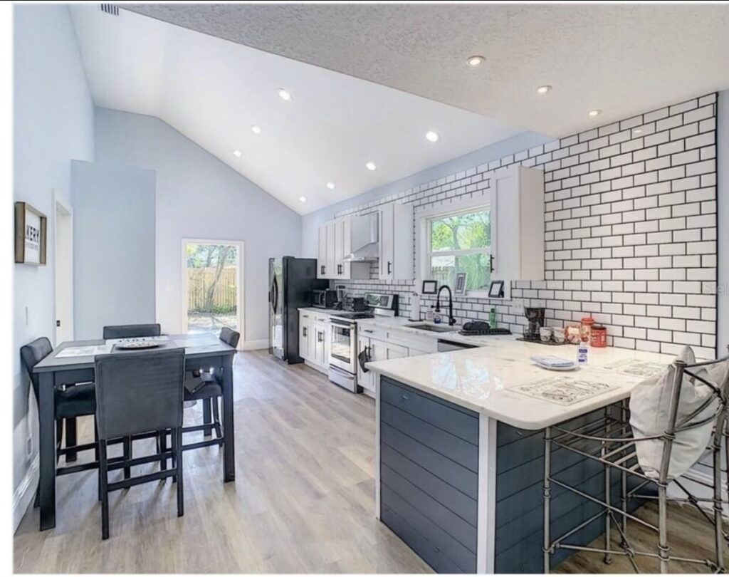 A kitchen with a large island and a table and chairs.