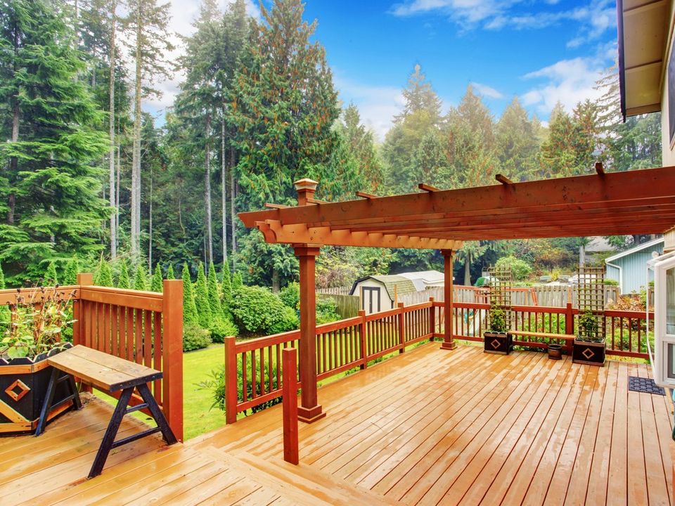 Spacious wooden deck with benches and attached pergola