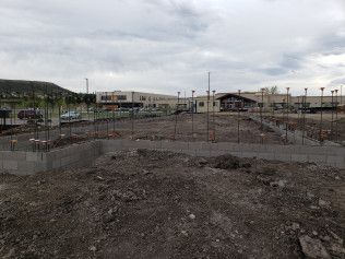 There is a lot of dirt in the foreground and a building in the background.