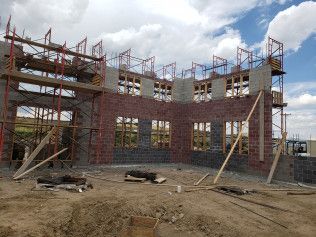 A large brick building is being built with scaffolding around it.